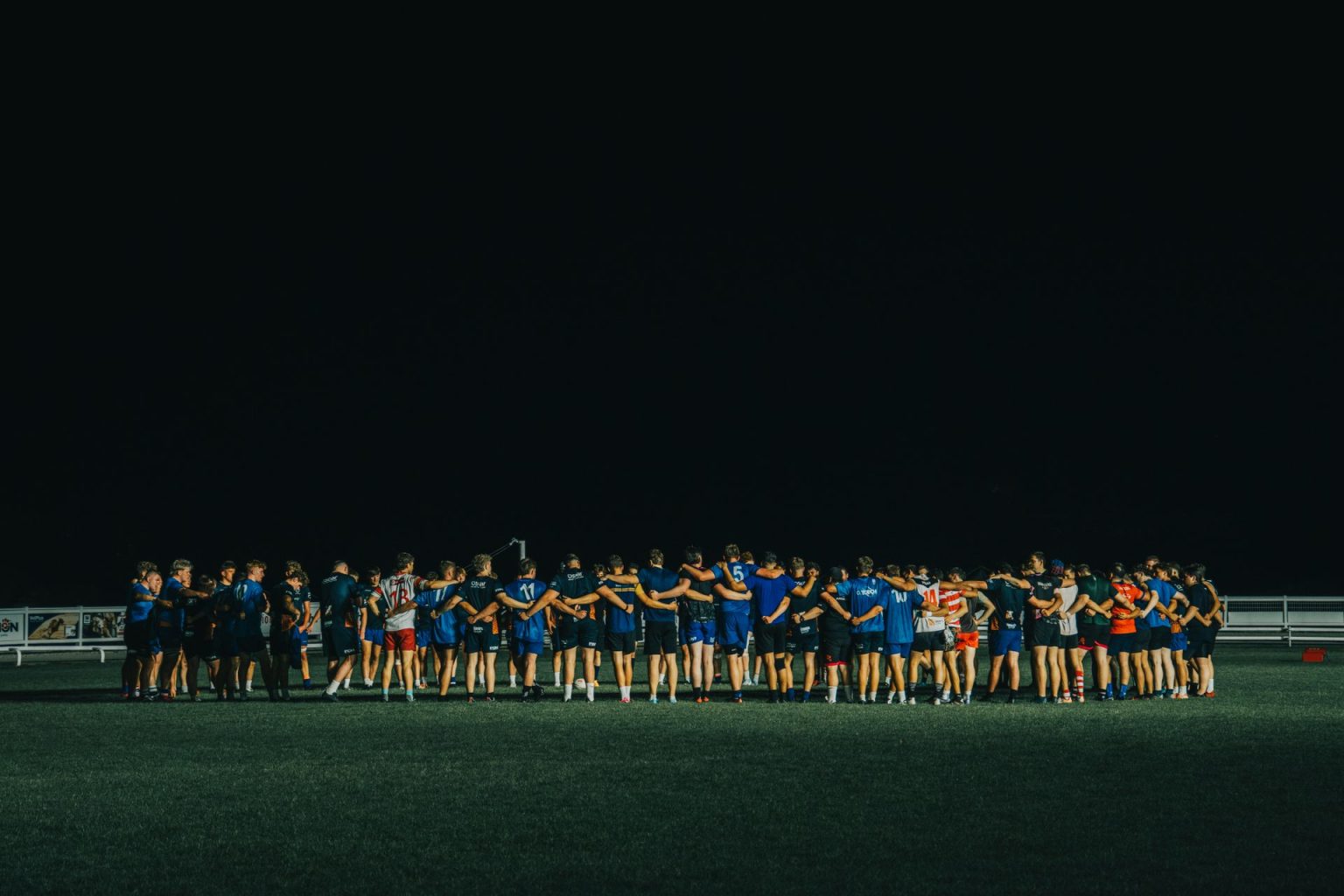 How International Football Can Shape the Rest of a Club Season A football squad gathered in a huddle on a floodlit pitch at night